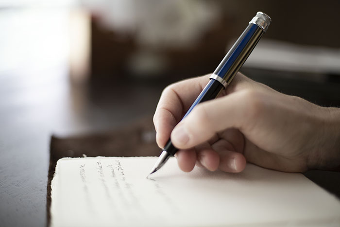 Journal Therapy. Photograph of a woman writing in a journal with a fountain pen. Copyright Jen Johnson.